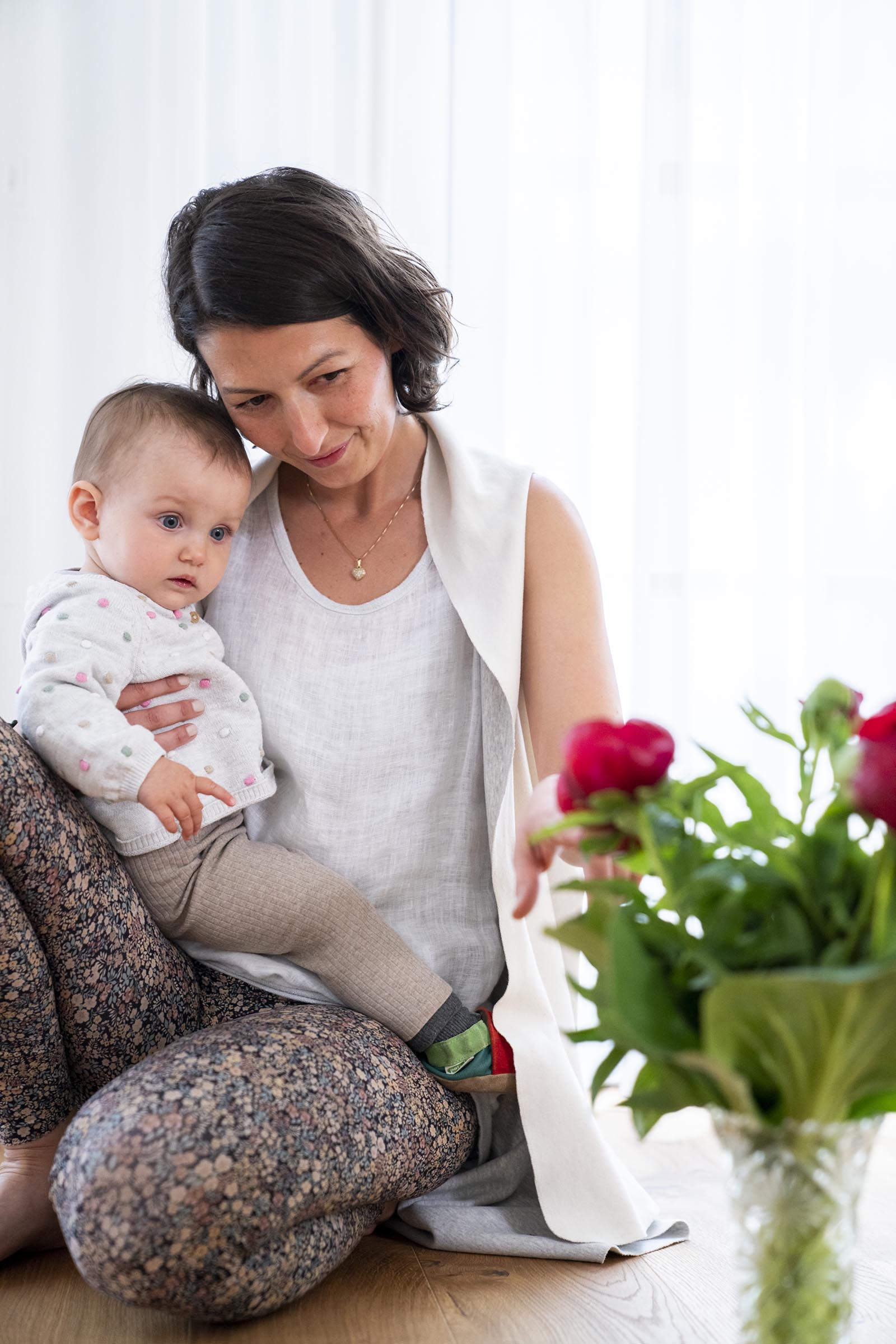 Jelena Drofenik-Premauer – #yogadoula – mit Baby in den Armen und auf Blumen zeigend Jelena Drofenik-Premauer - #yogadoula - mit Baby in den Armen und auf Blumen zeigend